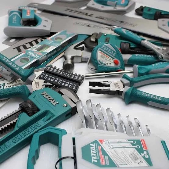 Surtido de herramientas manuales Total: llaves, alicates, martillo, cinta métrica y niveles sobre una mesa